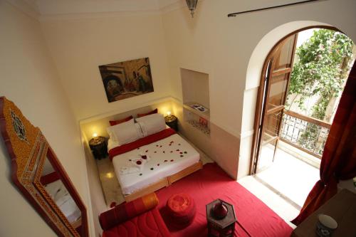 a bedroom with a bed and a large window at Riad white flowers in Marrakesh
