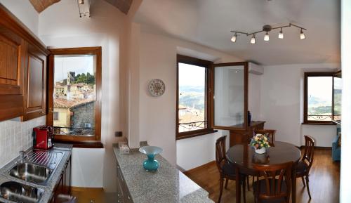 a kitchen and dining room with a table and some windows at Appartamento Clary in Montecatini Terme