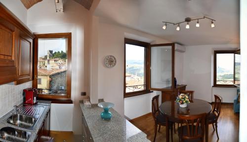 kuchnia i jadalnia ze stołem i oknami w obiekcie Appartamento Clary w Montecatini Terme