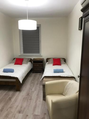 two beds in a room with a couch and a chair at Agroturystyka "Zielone Zacisze" in Łagów