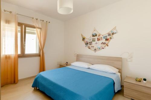 a bedroom with a blue bed and a window at Casa Vacanze La Primitiva in Manduria