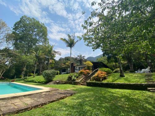 a house with a yard with a swimming pool at Pinheiros do Rocio in Petrópolis
