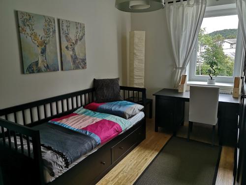 a bedroom with a bed and a desk and a window at Studios Am Wienerwald in Hinterbrühl