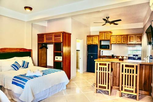 a bedroom with a bed and a kitchen at La Isla Resort in Caye Caulker