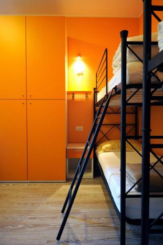 a bedroom with two bunk beds and an orange wall at Ostello La Sosta in Contrada Anselmi
