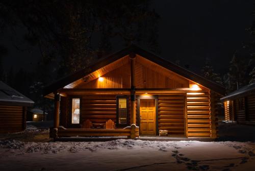 a log cabin at night in the snow at Castle Mountain Chalets in Castle Junction