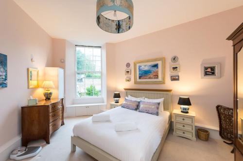 een slaapkamer met een groot wit bed en een raam bij Huntly Street in Edinburgh