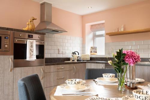 a kitchen with a wooden table with chairs and a dining room at Bramble Cottage in Turriff