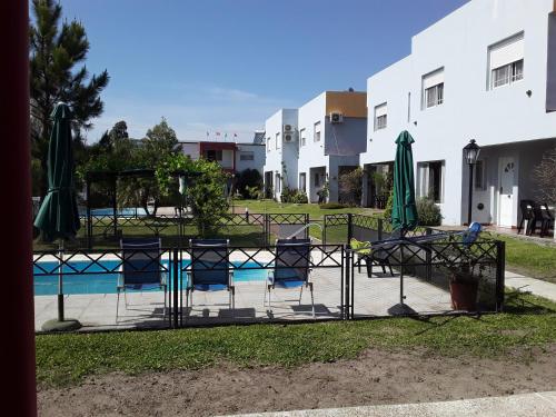 una valla con sillas y sombrillas junto a una piscina en Irundy Apartments, en Federación