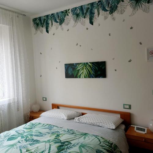 a bedroom with a bed and a plant on the wall at Rio Taglio in Cervignano del Friuli