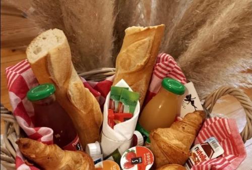 uma cesta de comida com pão, bebidas e pastelaria em le one em Agen