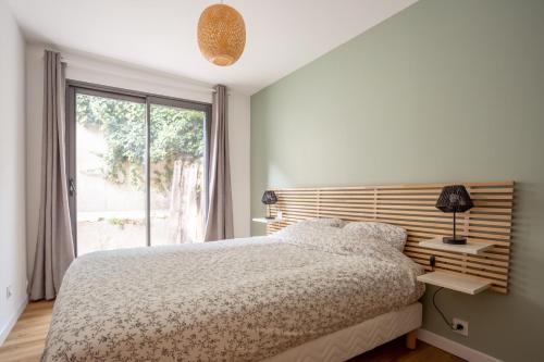 une chambre blanche avec un lit et une fenêtre dans l'établissement Atypique coeur de Vannes avec jardin, à Vannes