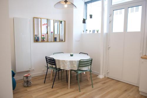 a dining room with a table and chairs at CHARMING Parisian Apartment WITH AIR CONDITIONING - CLIMATISATION & 2 BEDROOMS - Batignolles PARIS in Paris