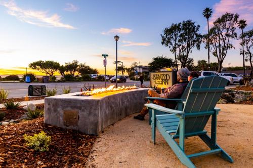 a man sitting in a chair next to a fire pit at Baywood Inn Bed & Breakfast in Los Osos