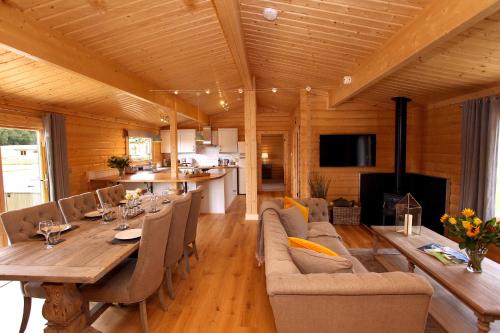 a dining room and living room with a table and chairs at Cambridgeshire Lakes - luxury lodges in a stunning lake location in Gamlingay