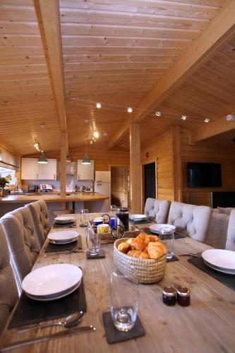 a wooden table with a basket of bread on it at Cambridgeshire Lakes - luxury lodges in a stunning lake location in Gamlingay