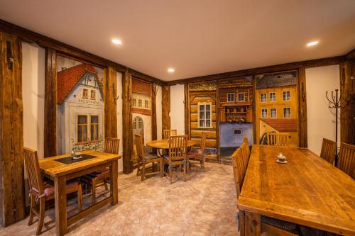 a dining room with wooden tables and chairs at Penzion Panský dům in Kvilda