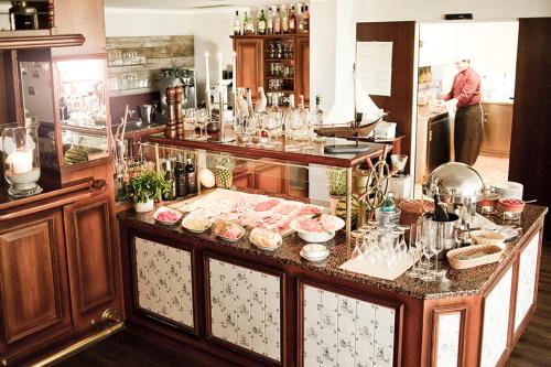 a kitchen with a counter with a lot of dishes at Hotel Strandhof in Baltrum