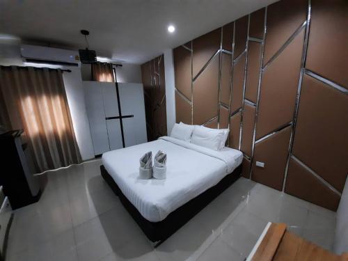 a bedroom with a bed with two shoes on it at Debua Mahasarakham in Maha Sarakham