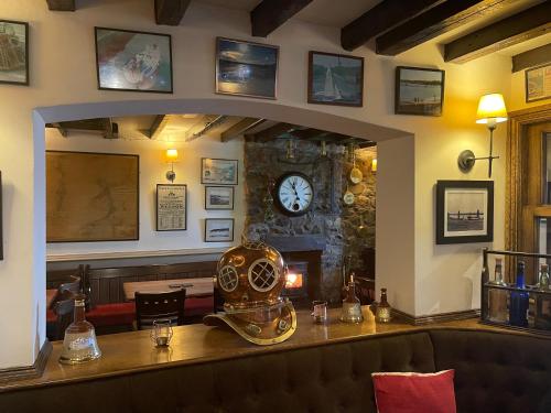 a kitchen with a clock on the wall at Garddfon Inn in Y Felinheli