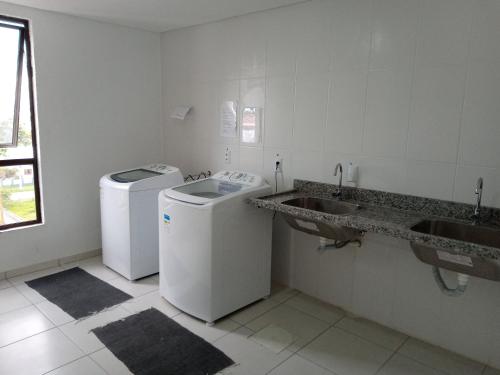 a white bathroom with two sinks and a washing machine at Loft torres Las piedras praia da Cal in Torres