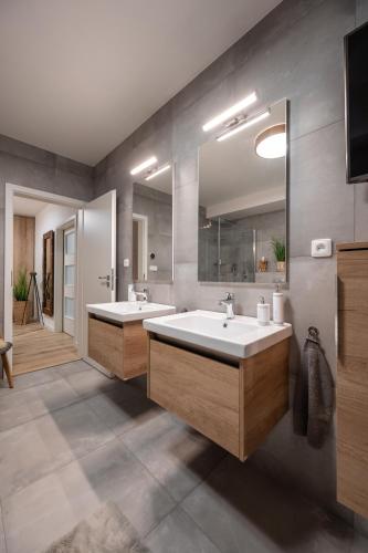a bathroom with two sinks and a large mirror at Apartmány Kaskády Luhačovice in Luhačovice