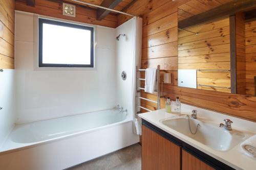 a bathroom with a tub and a sink and a bath tubermottermott at Retro Inn 1 - Lake Tekapo in Lake Tekapo