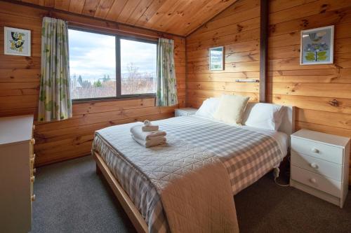 a bedroom with a bed in a log cabin at Retro Inn 1 - Lake Tekapo in Lake Tekapo