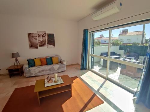 a living room with a couch and a large window at Vila Magna near The Strip with BBQ, AC, Balcony, Parking, 4 TVs and Free wifi in Albufeira