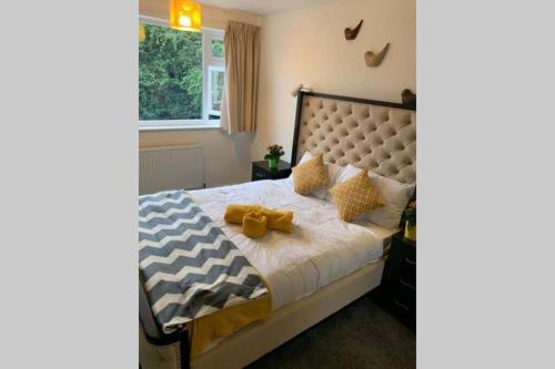 a bedroom with a large bed with a large headboard at Large 4 Bedroom House in Central Coventry in Walsgrave on Sowe