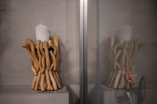 a shelf with a candle and some sticks at Apartmány Kaskády Luhačovice in Luhačovice