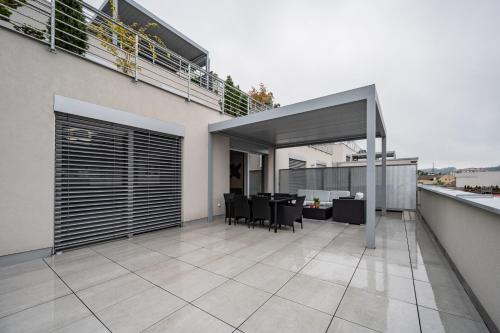 an open patio with a table and chairs on a balcony at Apartmány Kaskády Luhačovice in Luhačovice