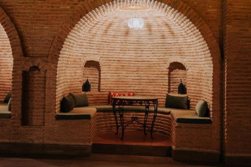 a brick room with a bench and a table at Borj Des Cascades & Spa in Ouzoud