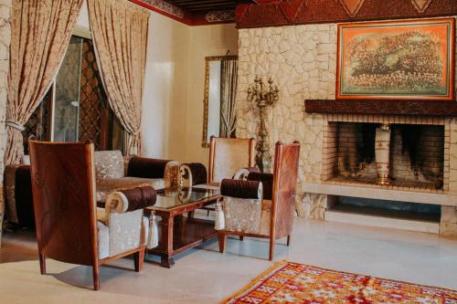 a living room with a couch and chairs and a fireplace at Borj Des Cascades & Spa in Ouzoud