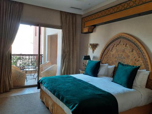 a hotel room with a large bed and a balcony at Borj Des Cascades & Spa in Ouzoud