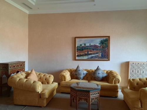 a living room with couches and a painting on the wall at Borj Des Cascades & Spa in Ouzoud