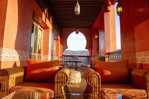a room with a couch and chairs on a balcony at Borj Des Cascades & Spa in Ouzoud