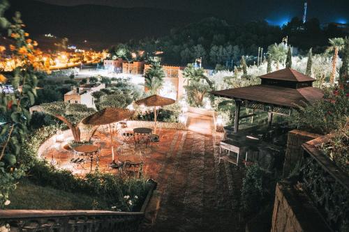 a patio with tables and umbrellas at night at Borj Des Cascades & Spa in Ouzoud