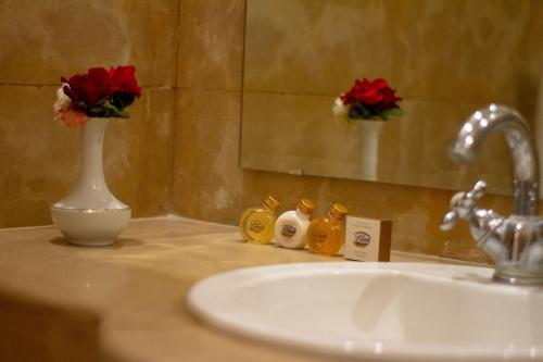 a bathroom counter with a sink and a vase with flowers at Borj Des Cascades & Spa in Ouzoud