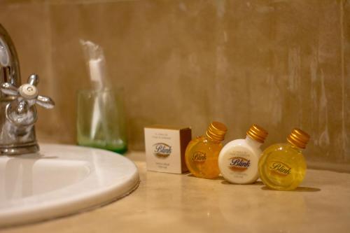 a bathroom with three bottles of soap and a sink at Borj Des Cascades & Spa in Ouzoud