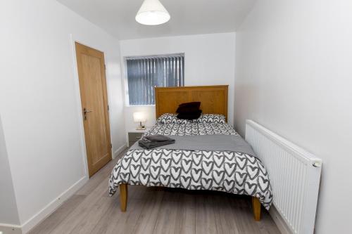 Comfortable stay in Shirley, Solihull - Room 1 في برمنغهام: غرفة نوم بسرير عليها قطة سوداء