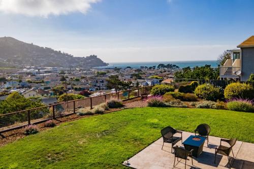 a patio with two chairs and a table on the grass at Entire Ocean View Home beaches hiking restaurants family activities in Pacifica