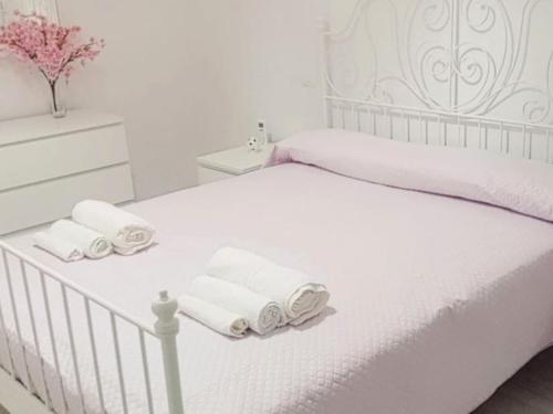 a white bedroom with a bed with towels on it at Anna's House in Taranto