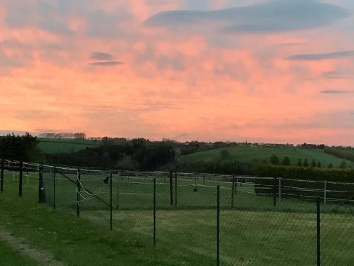 a fence in a field with a sunset at Fewo Eifeler Edelsteine „Aquamarin“ in Schleiden