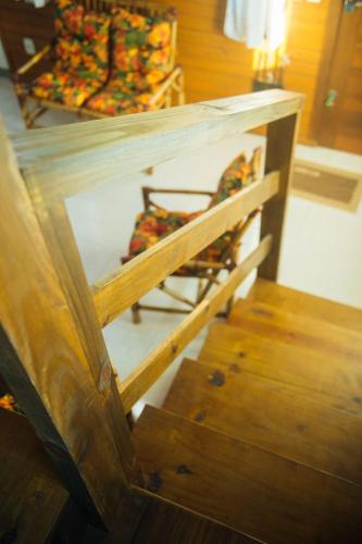 a wooden table with a chair and some stairs at Recanto do Mar in Balneário Gaivotas