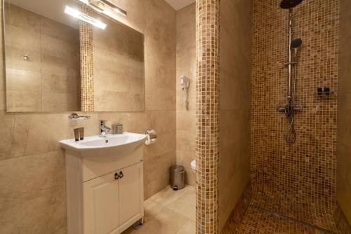 a bathroom with a sink and a shower at Rediu Hotel & Restaurant in Botoşani