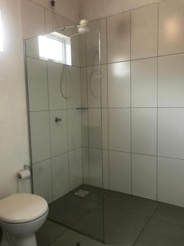 a bathroom with a glass shower with a toilet at Chácara buriti in Pirenópolis
