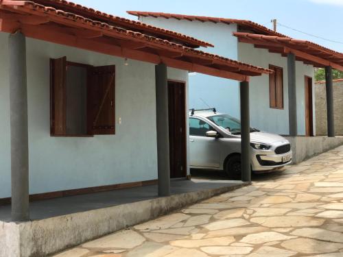 a car parked next to a house with a carport at Chácara buriti in Pirenópolis