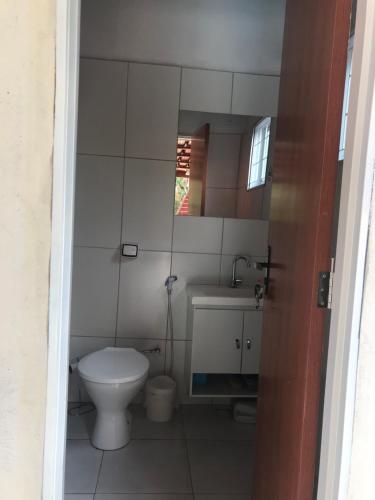 a bathroom with a toilet and a sink and a mirror at Chácara buriti in Pirenópolis