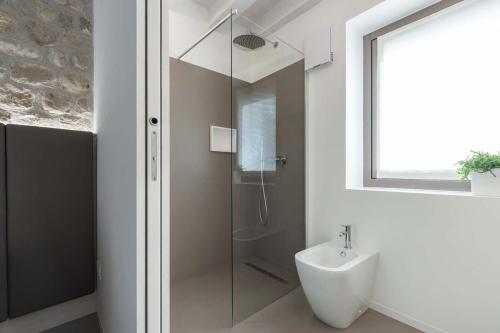 a bathroom with a glass shower and a sink at Portone180 Guest House in Roveredo in Piano